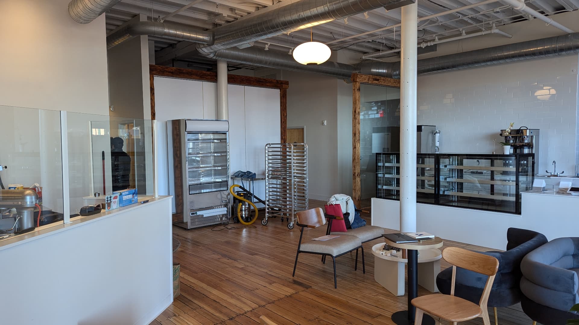 Renovated cafe with white counter, subway tile, timber framing, and wood floors in Portland, Maine