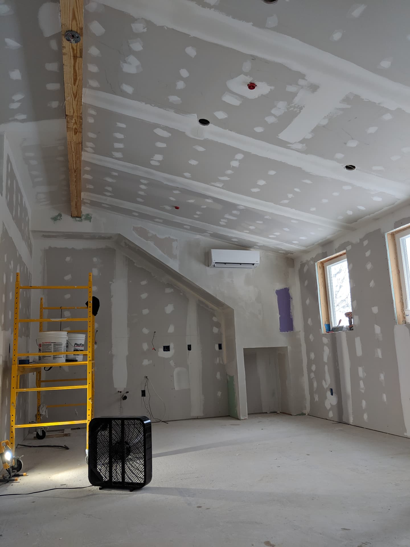 Unfinished attic space with taped drywall and vaulted ceiling before kitchen build-out in Portland, Maine