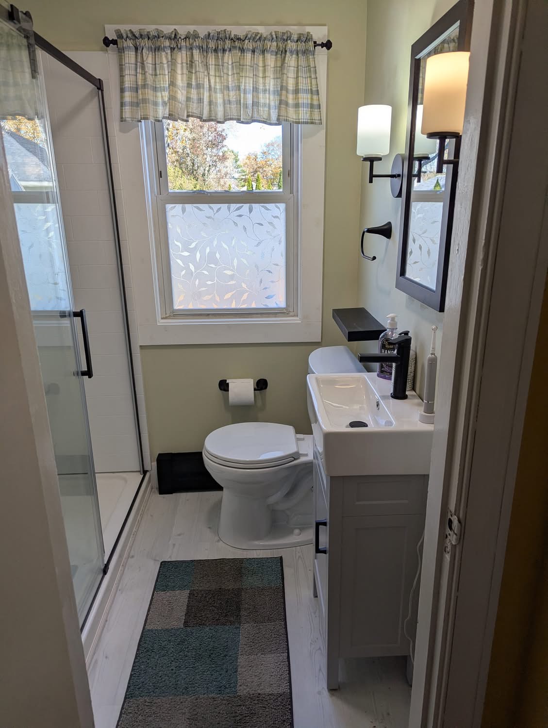 Small bathroom remodel with walk-in shower, new vanity, and matte black fixtures in Portland, Maine