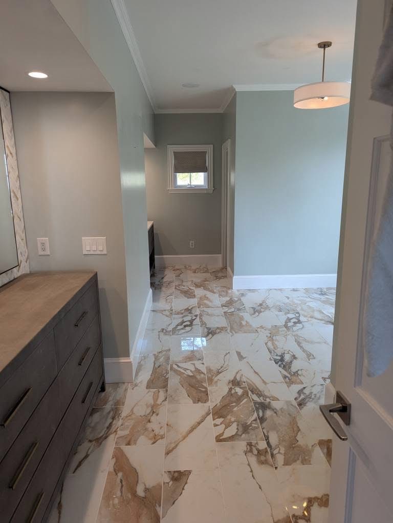 Bathroom remodel with polished marble-look porcelain tile floor and double vanity in Portland, Maine