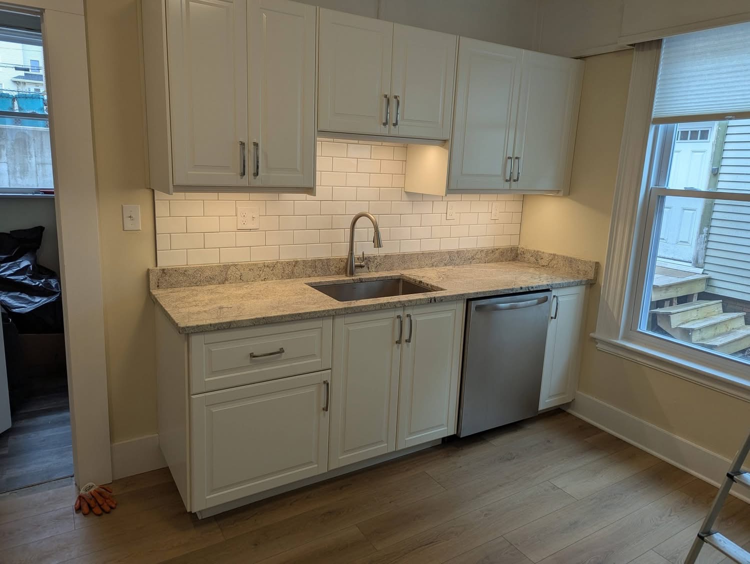 Kitchen remodel with white cabinets, granite counters, subway tile backsplash, and under-cabinet lighting in Portland, Maine