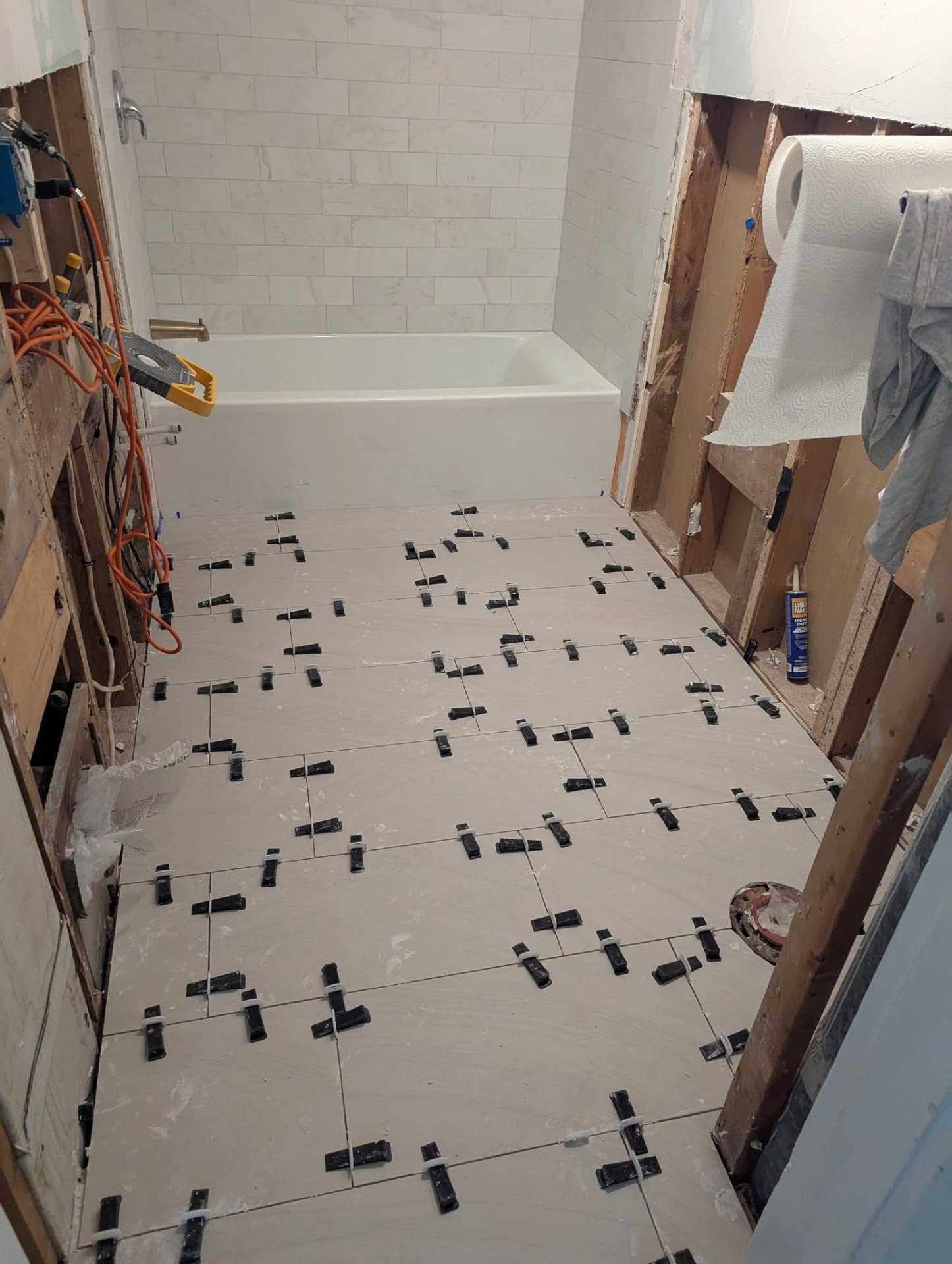 Bathroom gutted during renovation with tile being installed before remodel in Portland, Maine