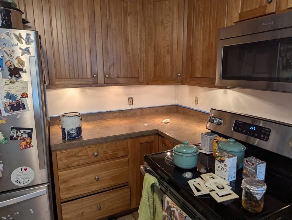 Kitchen wall prepped and taped before subway tile backsplash installation in Portland, Maine