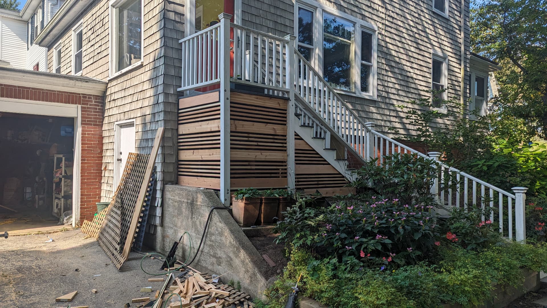 New horizontal cedar slat skirting under white exterior stairs in Portland, Maine