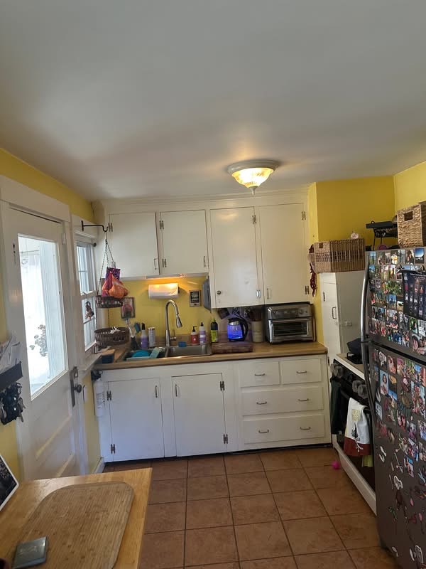 Dated kitchen with old cabinets and fluorescent lighting before remodel in Portland, Maine