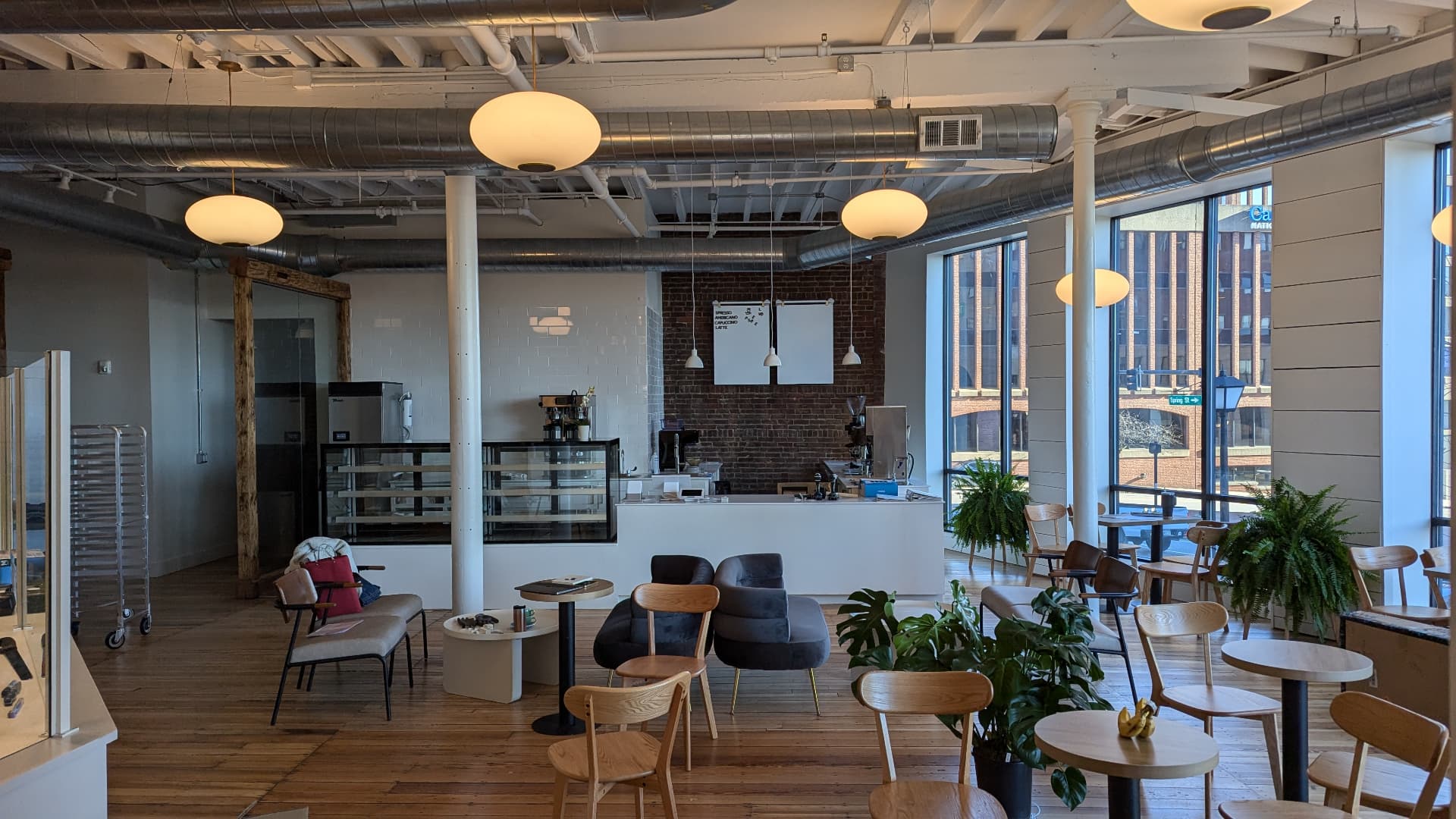 Finished cafe with white service counter, subway tile, brick wall, and seating in Portland, Maine