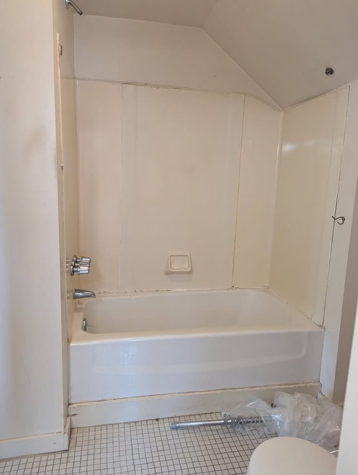 Old fiberglass tub surround before replacement in a Portland, Maine bathroom