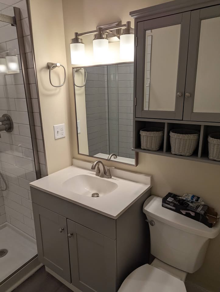 Bathroom vanity installation with gray shaker cabinet, cultured marble top, and matching medicine cabinet in Portland, Maine