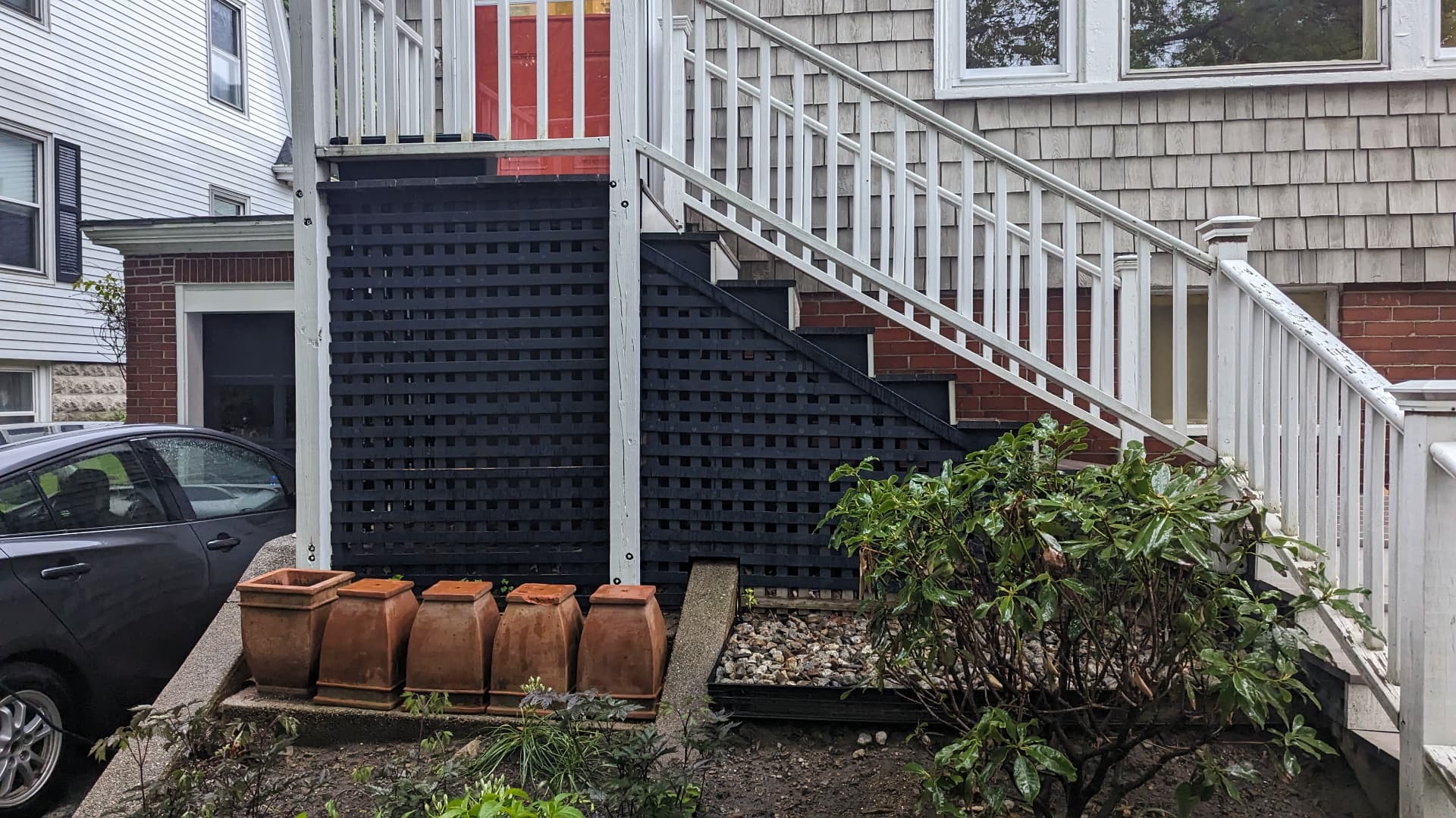 Old black lattice under exterior stairs before replacement in Portland, Maine